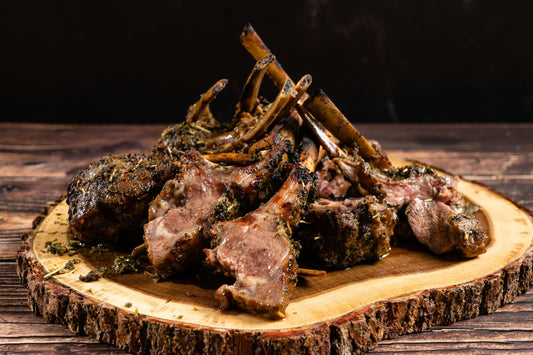 a plate of roasted lamb chops on a wooden table